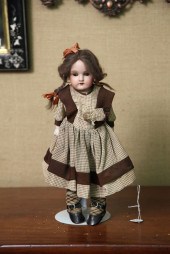 SMALL BISQUE HEAD DOLL. Brown paperweight