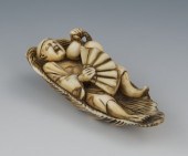 A Carved Ivory Netsuke of a Sleeping