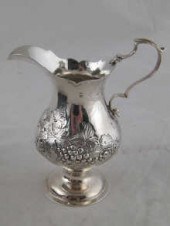 A Georgian silver cream jug with embossed