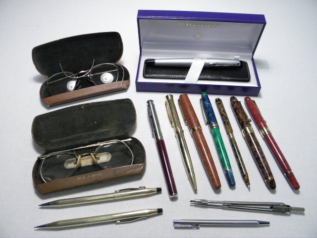 Group lot of assorted pens and eyeglasses.