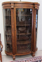 AN OAK AND CURVED GLASS CHINA CABINET