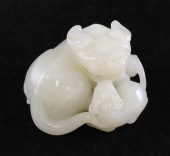 A Chinese white jade lion-dog and cub