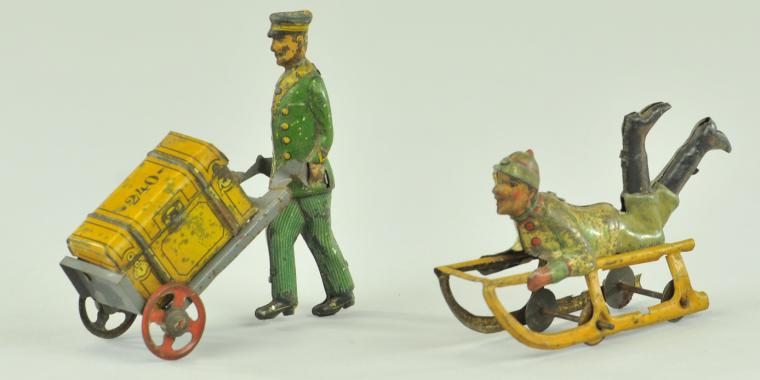 PORTER WITH LUGGAGE & BOY ON SLED PENNY TOY