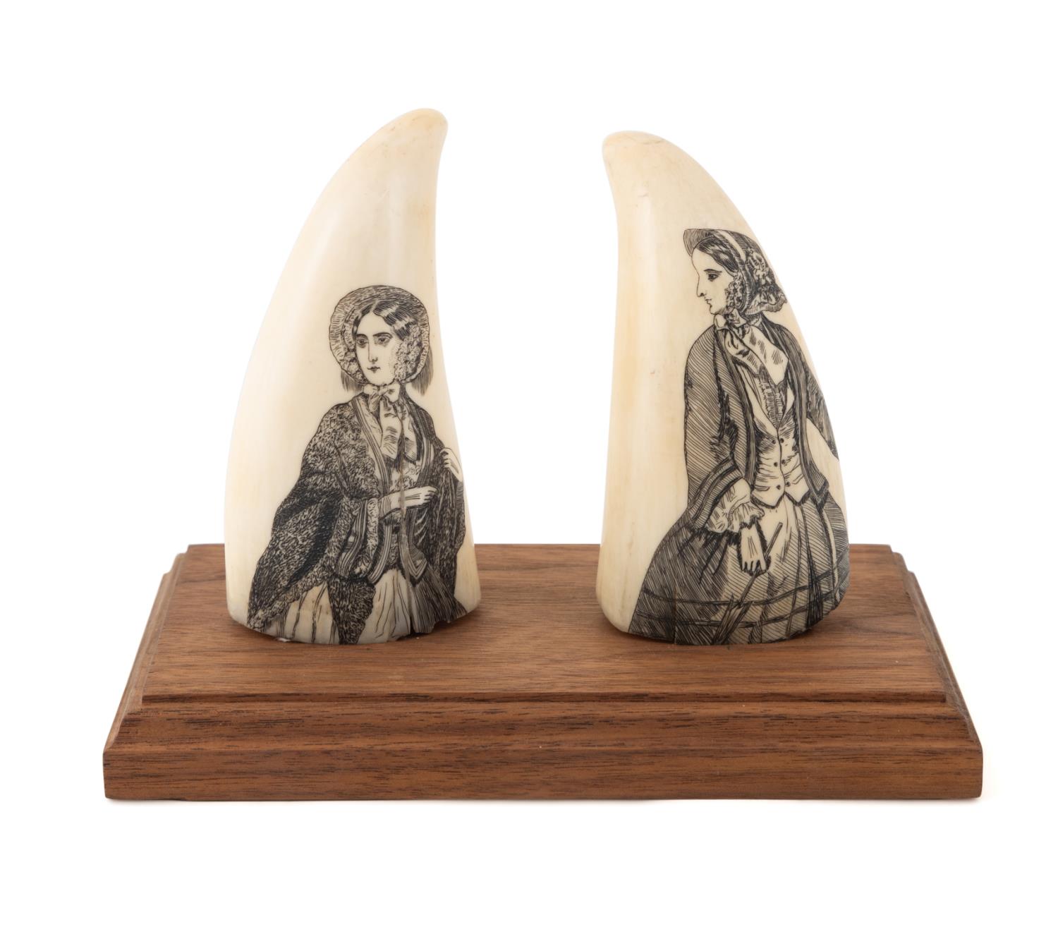 TWO SCRIMSHAW WHALE TEETH ON WOODEN 2fa5d7