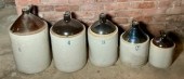 Five brown and white stoneware jugs,
