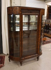 AN OAK AND CURVED GLASS CHINA CABINET,