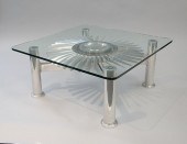 A MODERN STAINLESS STEEL AND GLASS TABLE