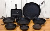 Eight vintage cast iron skillets, including: