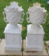 AN ANTIQUE PAIR OF CAST IRON URNS ON