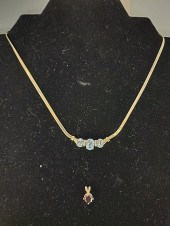 14K Gold and Blue Topaz Necklace features